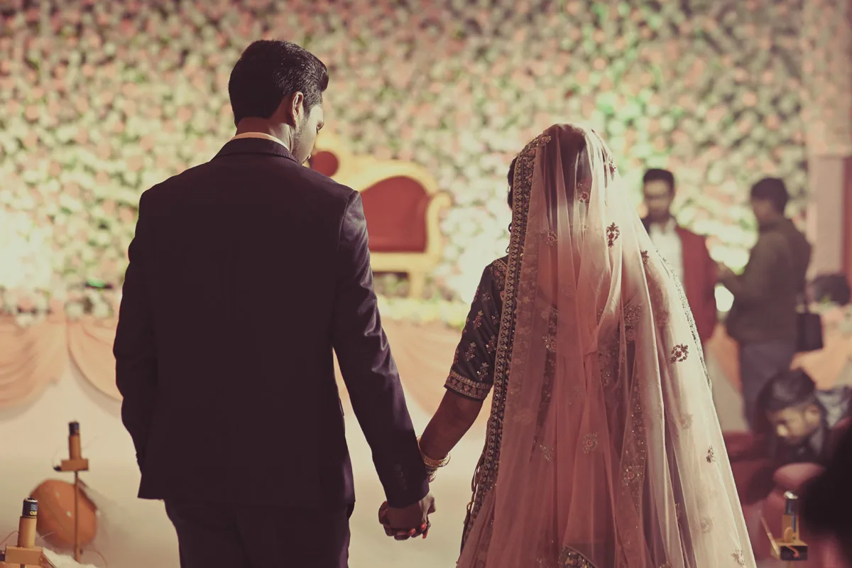 Reception photography in Patna, Delhi, Hajipur, Gaya | Bride and groom walking together at wedding reception | Elegant wedding reception cinematography | Candid couple moments captured by professional wedding photographer.